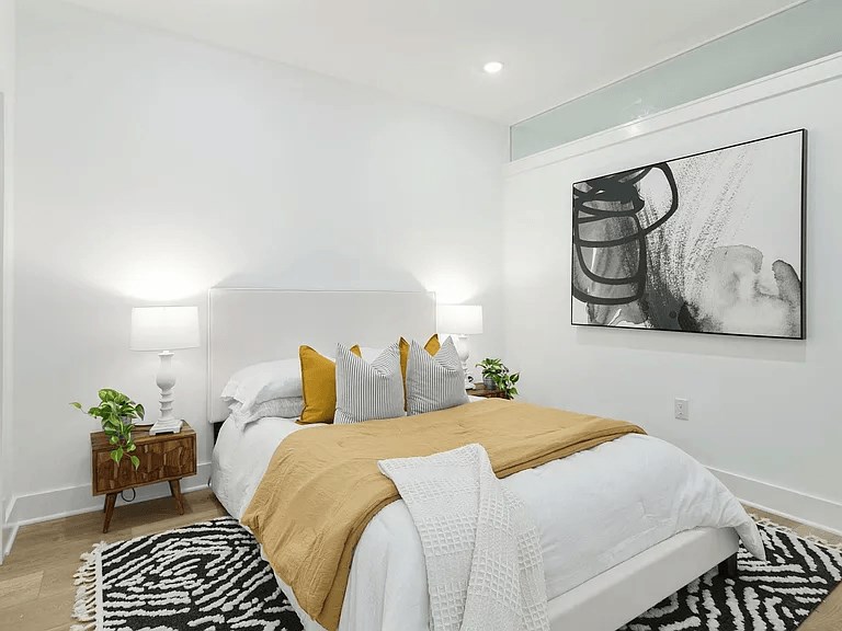 A bedroom with a large bed and a painting on the wall.