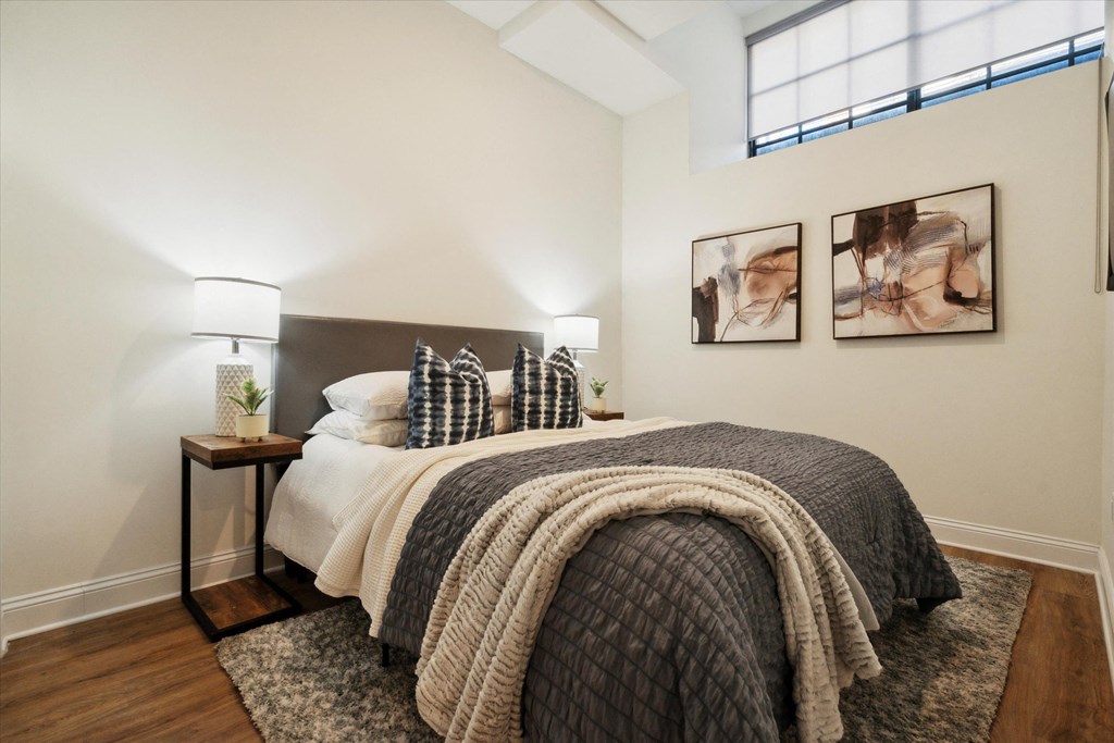 a bedroom with a bed and two paintings on the wall