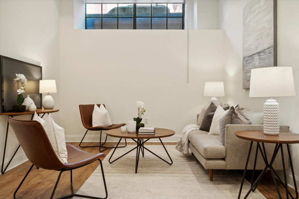 a living room with a couch and chairs and a tv