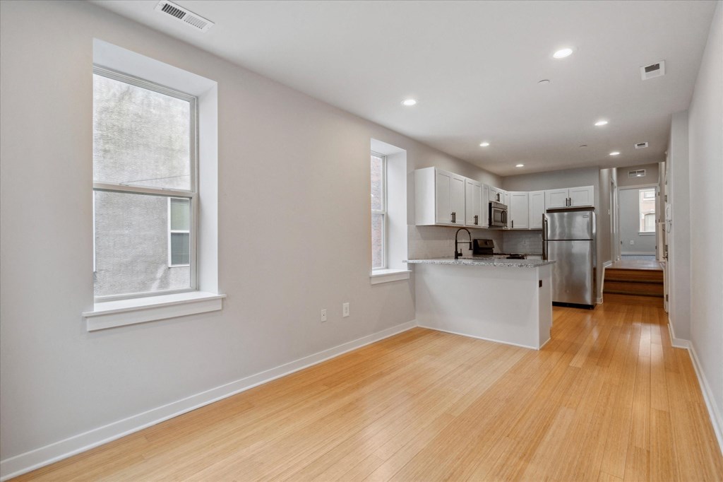 a living room with a kitchen and a large window
