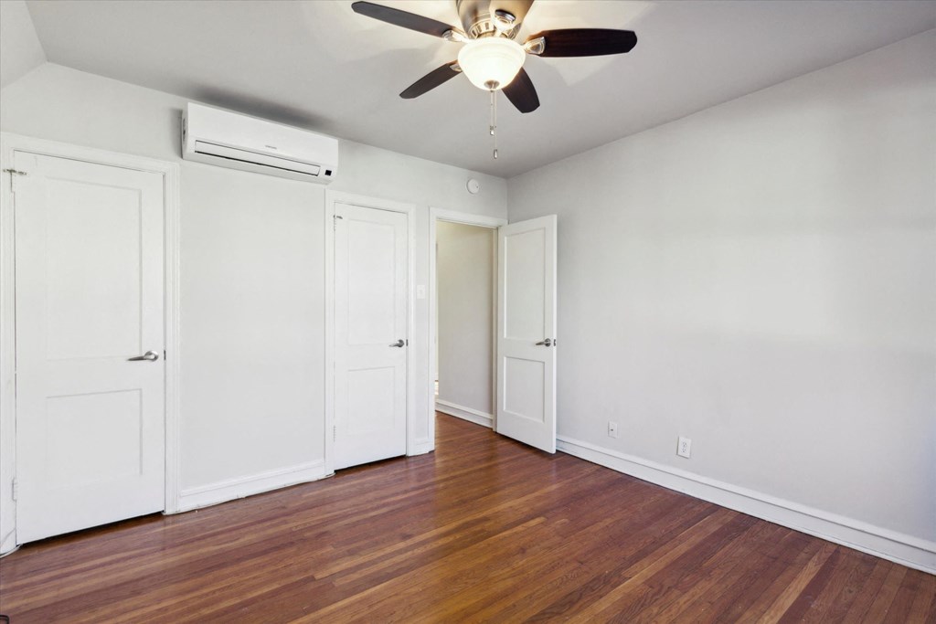 an empty room with a ceiling fan and a wood floor