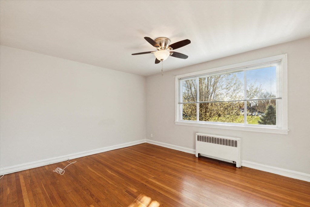 a living room with a large window and a ceiling fan