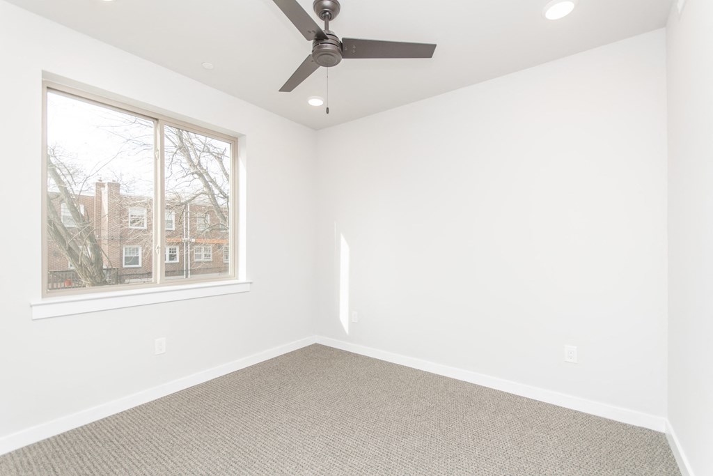 an empty room with white walls and a window