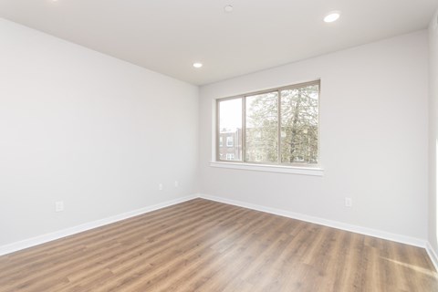 an empty room with white walls and a window