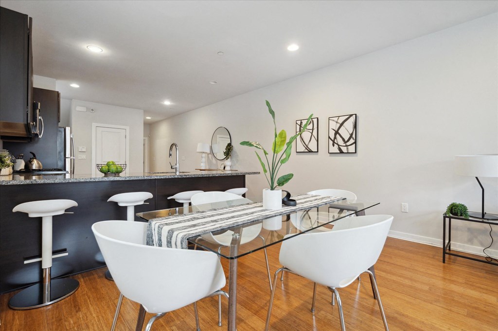 a dining room with a glass table and white chairs