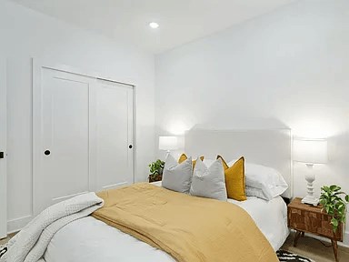 A bedroom with a bed, nightstand, and lamp.