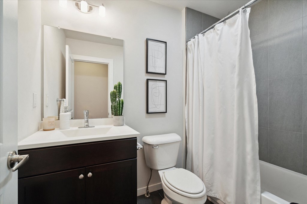 a bathroom with a shower and a toilet and a sink