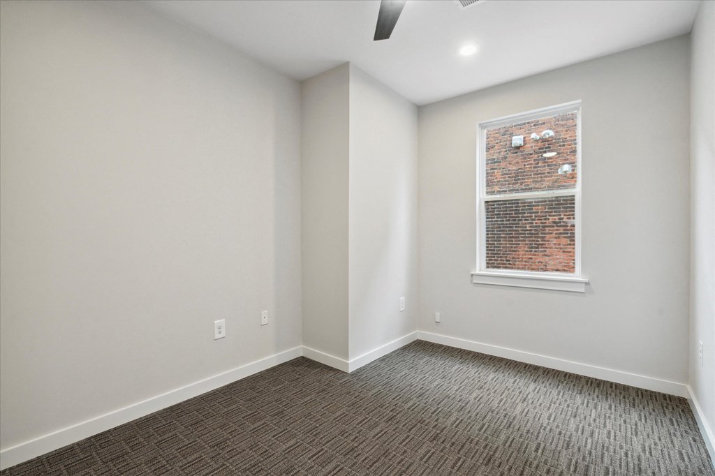 an empty room with white walls and a window