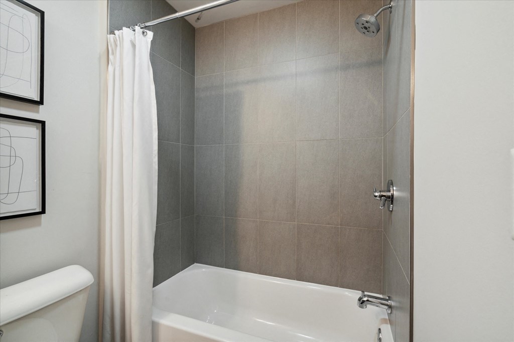 a bathroom with a shower and a tub and a curtain