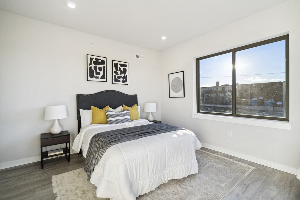 a bedroom with a bed and a large window