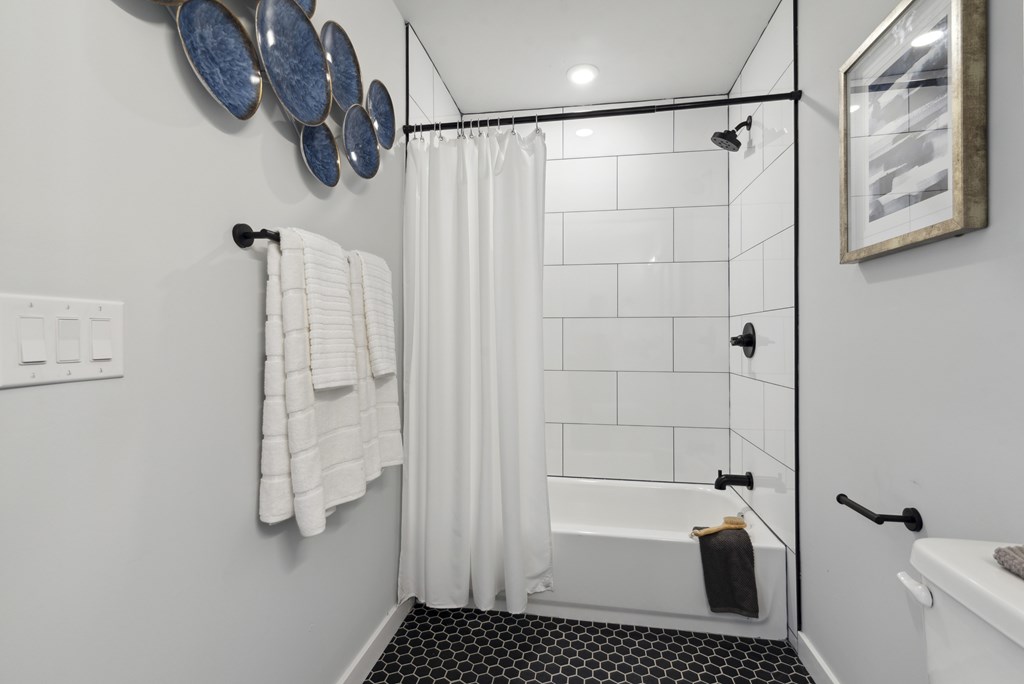A white bathroom with a black and white floor.