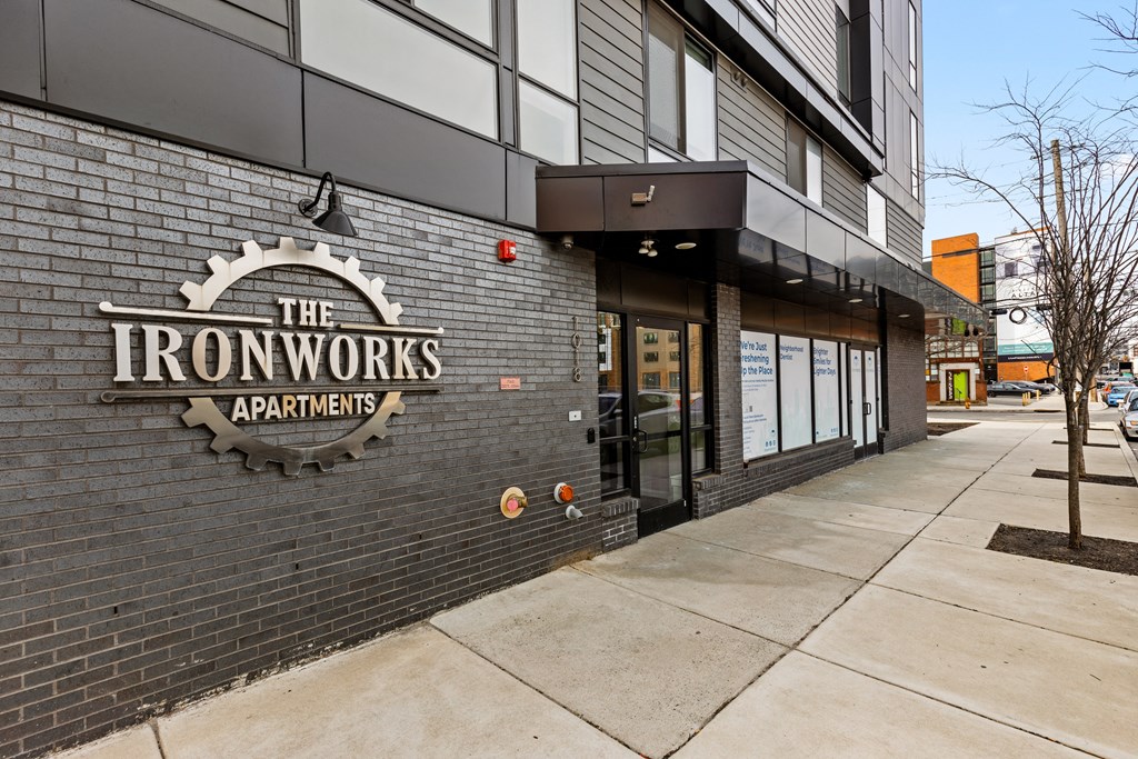 the front of the apartments building with a sign on the brick wall
