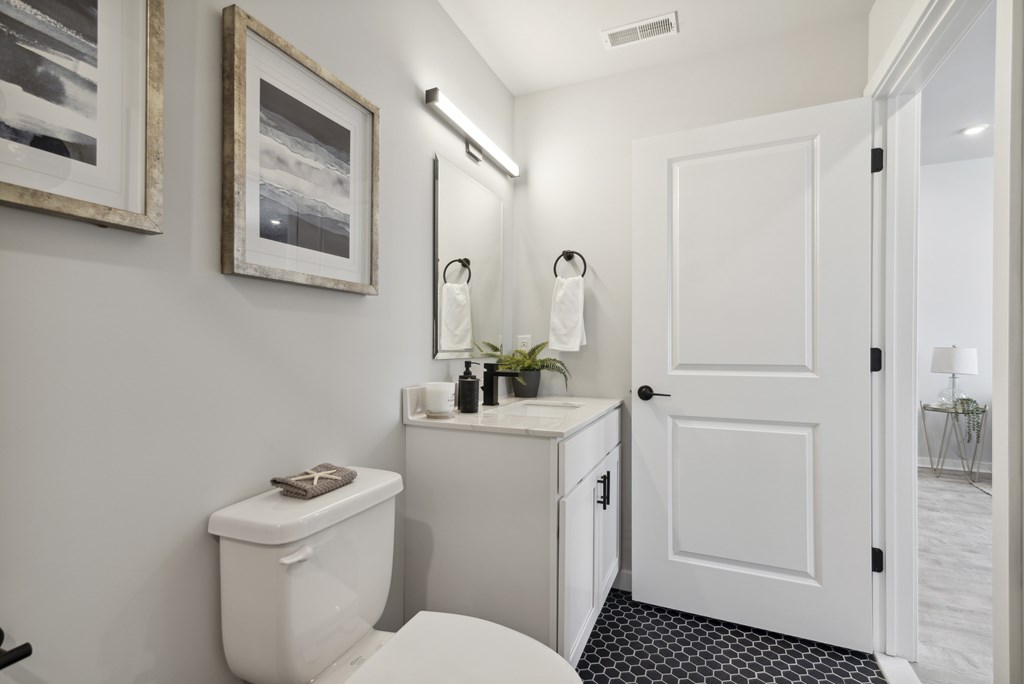 A white toilet sits next to a white cabinet in a bathroom.