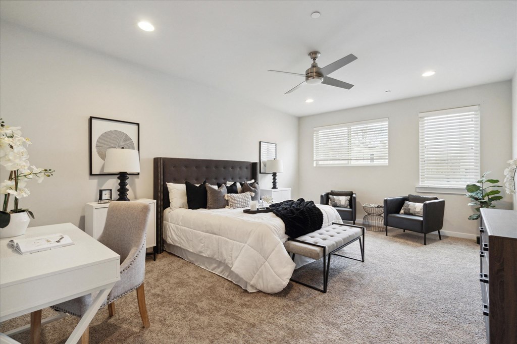 a large bedroom with a bed and a ceiling fan