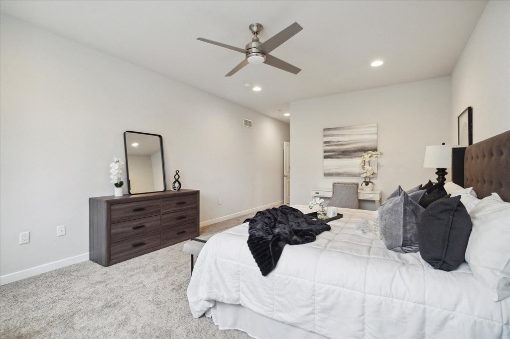 a bedroom with a large bed and a ceiling fan