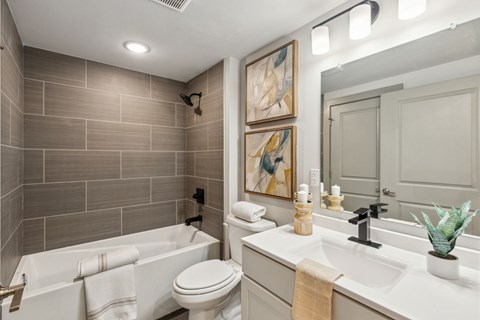 A bathroom with a white tub, toilet, and sink.
