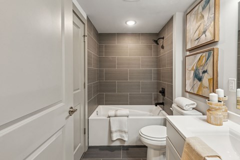 A bathroom with a white toilet, a white tub, and a white sink.