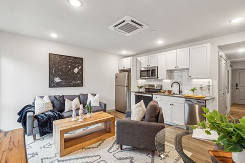 A modern living room with a grey couch and a wooden coffee table.