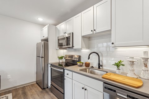 A kitchen with white cabinets and stainless steel appliances.