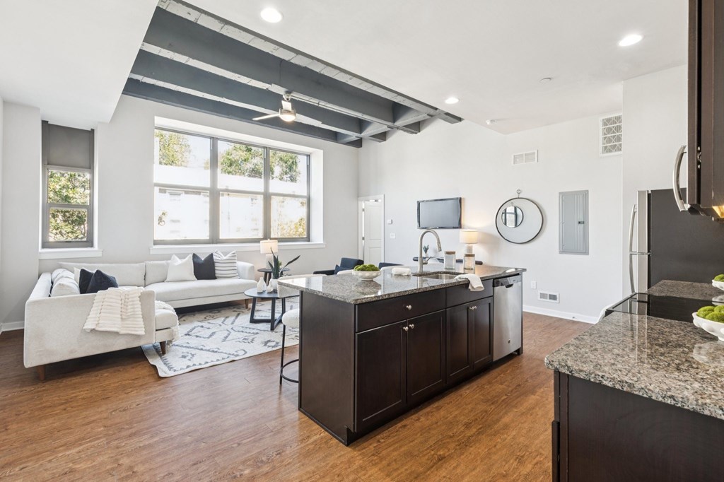 A modern kitchen with dark wood cabinets and a granite countertop.