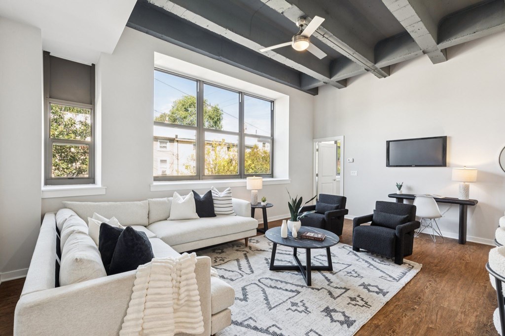 A living room with a white couch and a black coffee table.