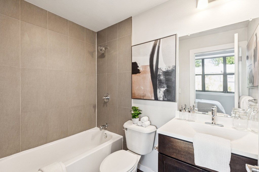 A white toilet sits next to a white sink in a bathroom.