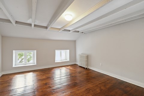 a bedroom with hardwood floors and a coffered ceiling