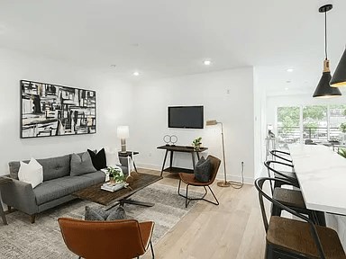 A living room with a grey couch, a coffee table, and a television.