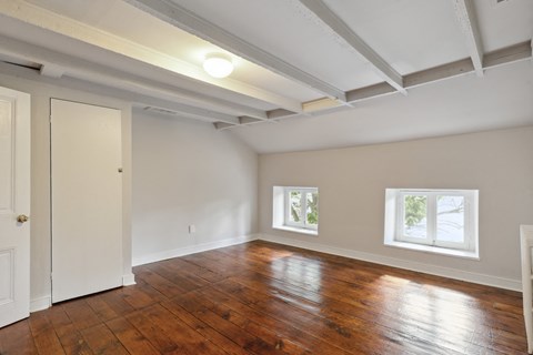 an empty living room with hardwood floors and a coffered ceiling