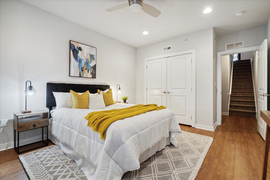 a bedroom with a large bed and a staircase