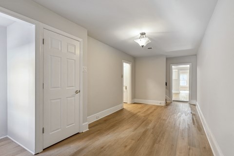 a bedroom with hardwood floors and white walls