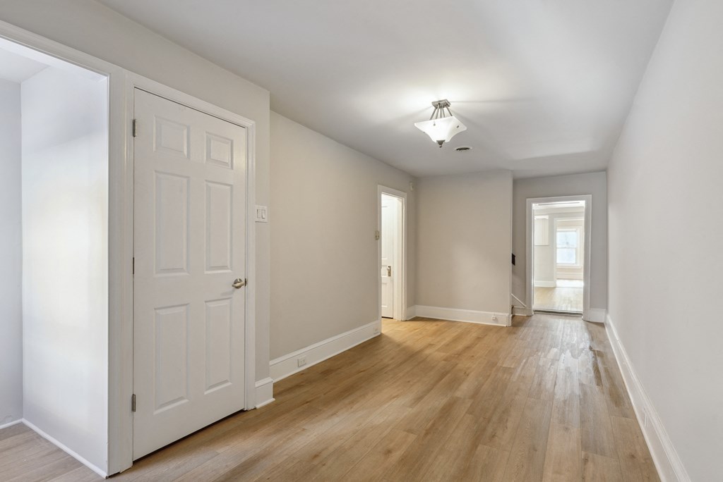 a bedroom with hardwood floors and white walls
