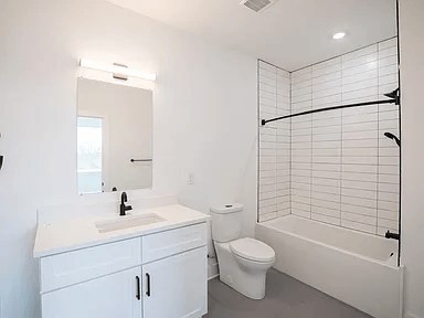 A white bathroom with a toilet, sink, and bathtub.