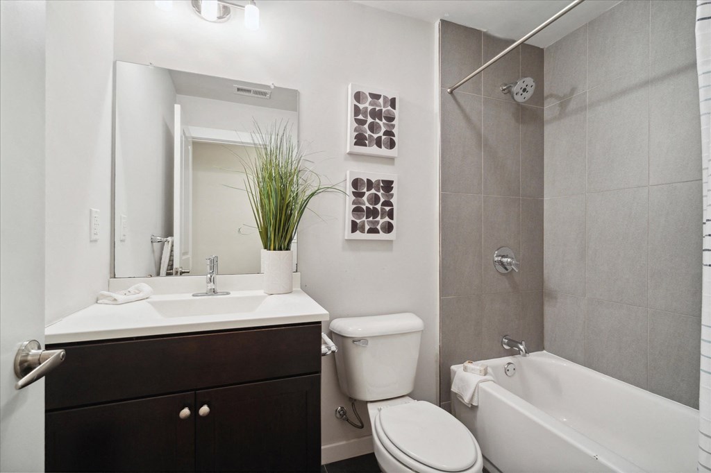 a bathroom with a toilet sink and shower and a mirror