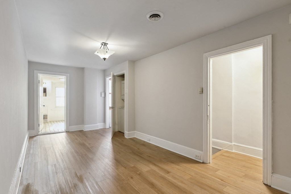a bedroom with hardwood floors and grey walls
