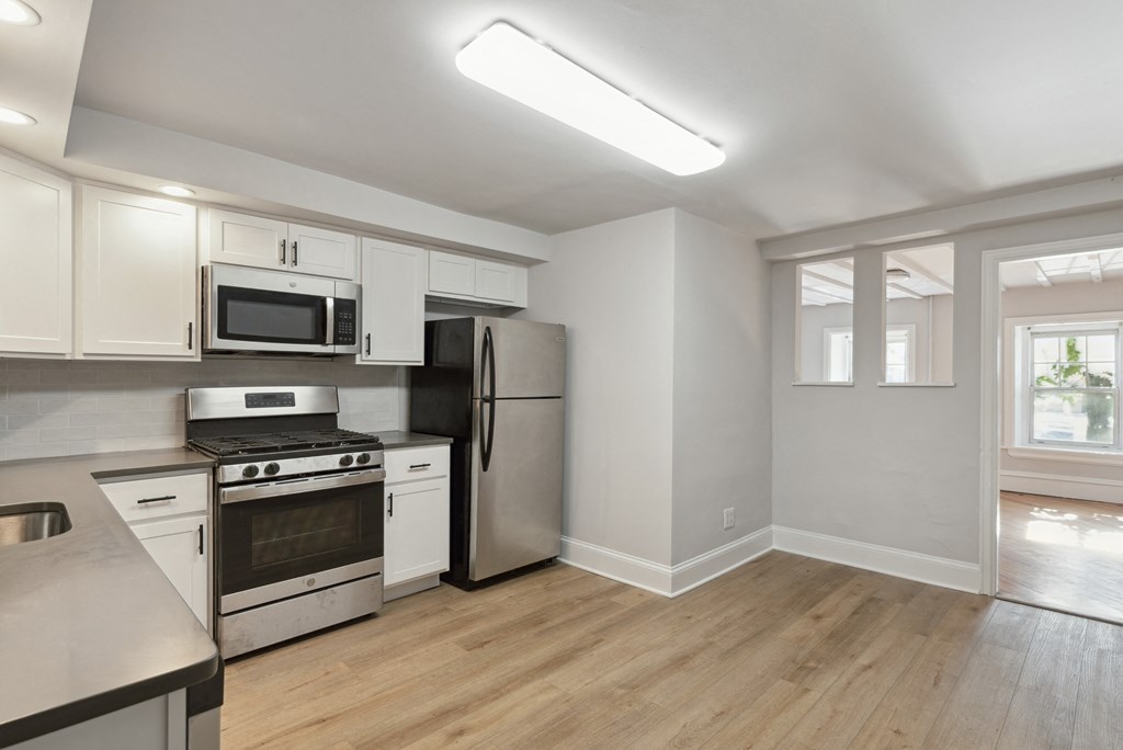 a kitchen with white cabinets and stainless steel appliances