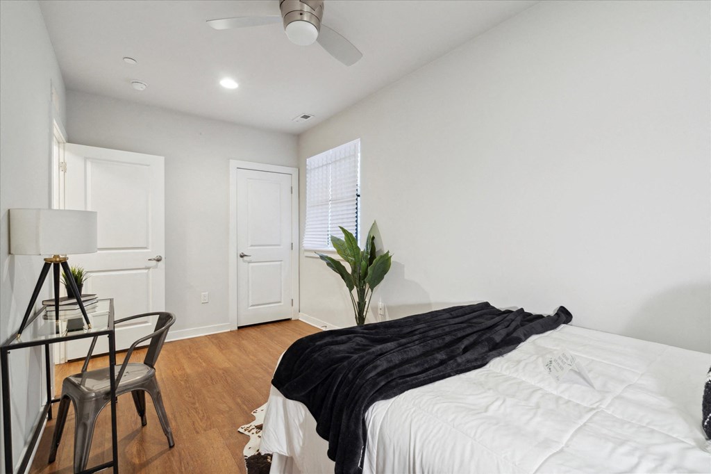 a bedroom with a large bed and a desk with a chair