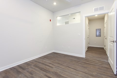 an empty living room with white walls and wood flooring