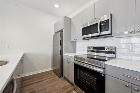 a kitchen with white cabinets and stainless steel appliances