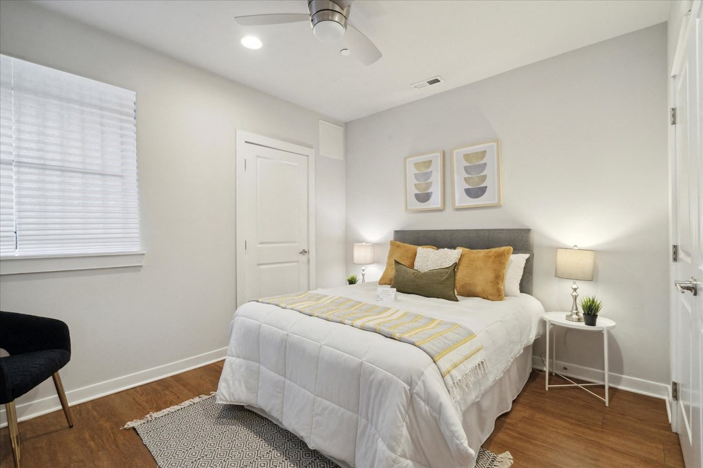 a bedroom with white walls and a white bed