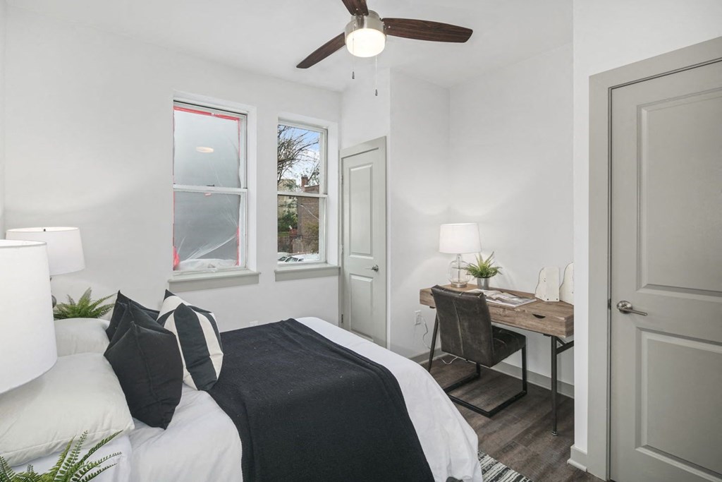 a bedroom with a large bed and a desk with a chair