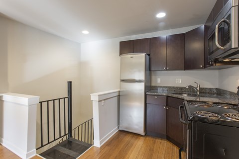 A kitchen with a black stove top oven and a white refrigerator.