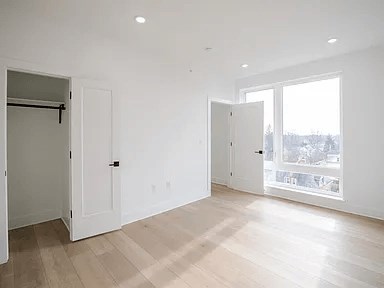 A large empty room with white walls and wooden flooring.