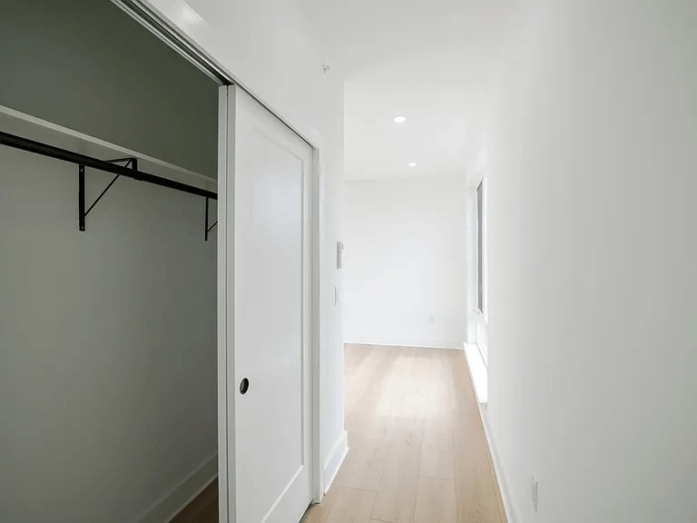 A white door is at the end of a hallway.