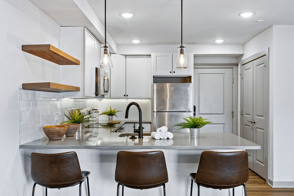 a kitchen with white cabinets and a marble counter top