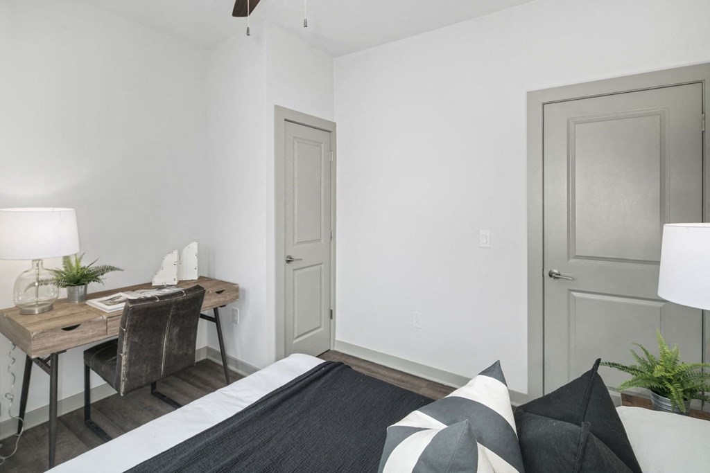 a bedroom with a bed and a desk with a chair