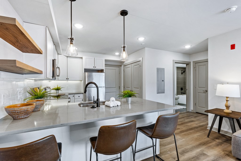an open kitchen with a large island with chairs