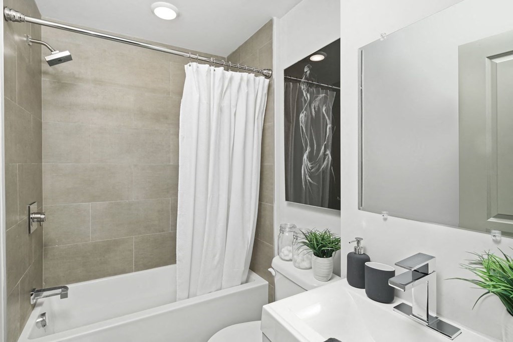 a bathroom with a white sink and a white shower curtain