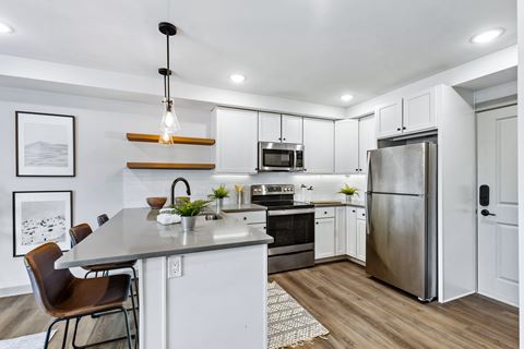 a kitchen with white cabinets and a stainless steel refrigerator