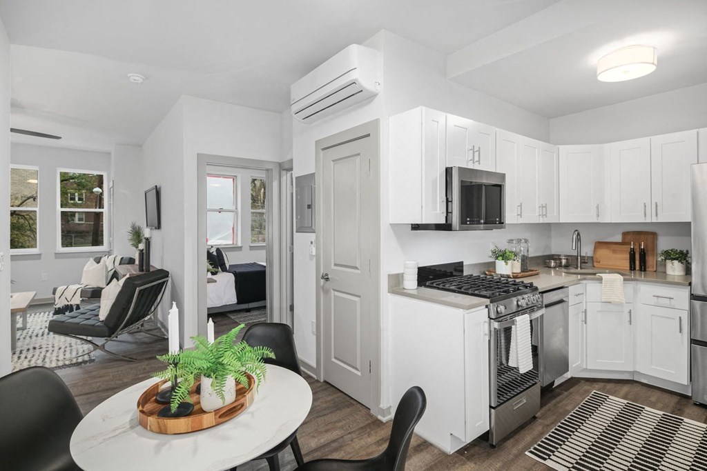 a kitchen with white cabinetry and a white table with black chairs